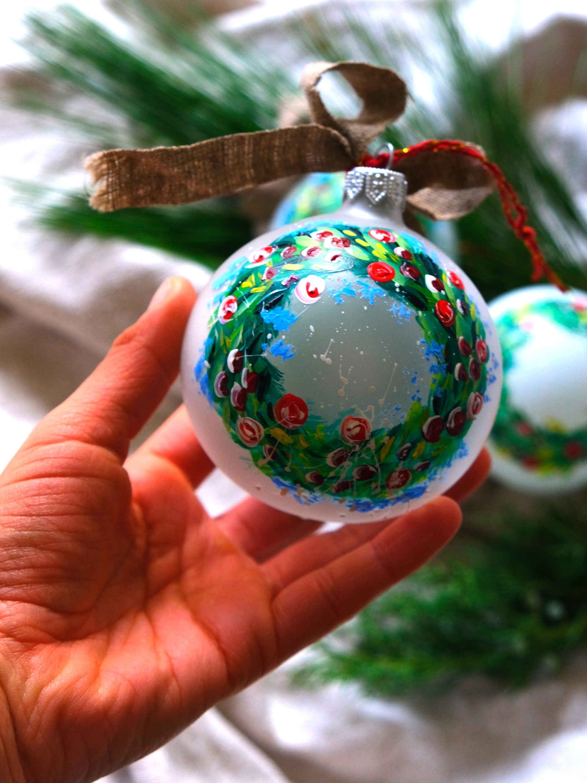 bombka z namalowanym świątecznym wiankiem